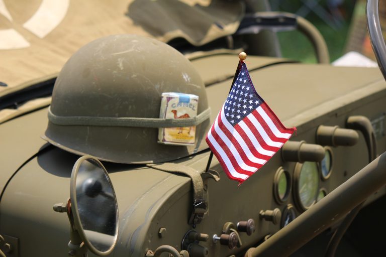 Army tank with helmet and American flag on top - honor our veterans on memorial day
