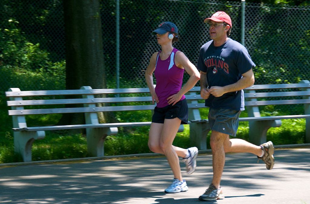 A man and woman are jogging in the park as part of their Fitquest fitness quest