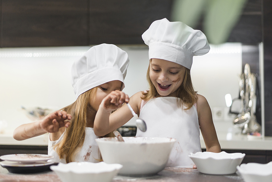 happy kids cooking at the kitchen