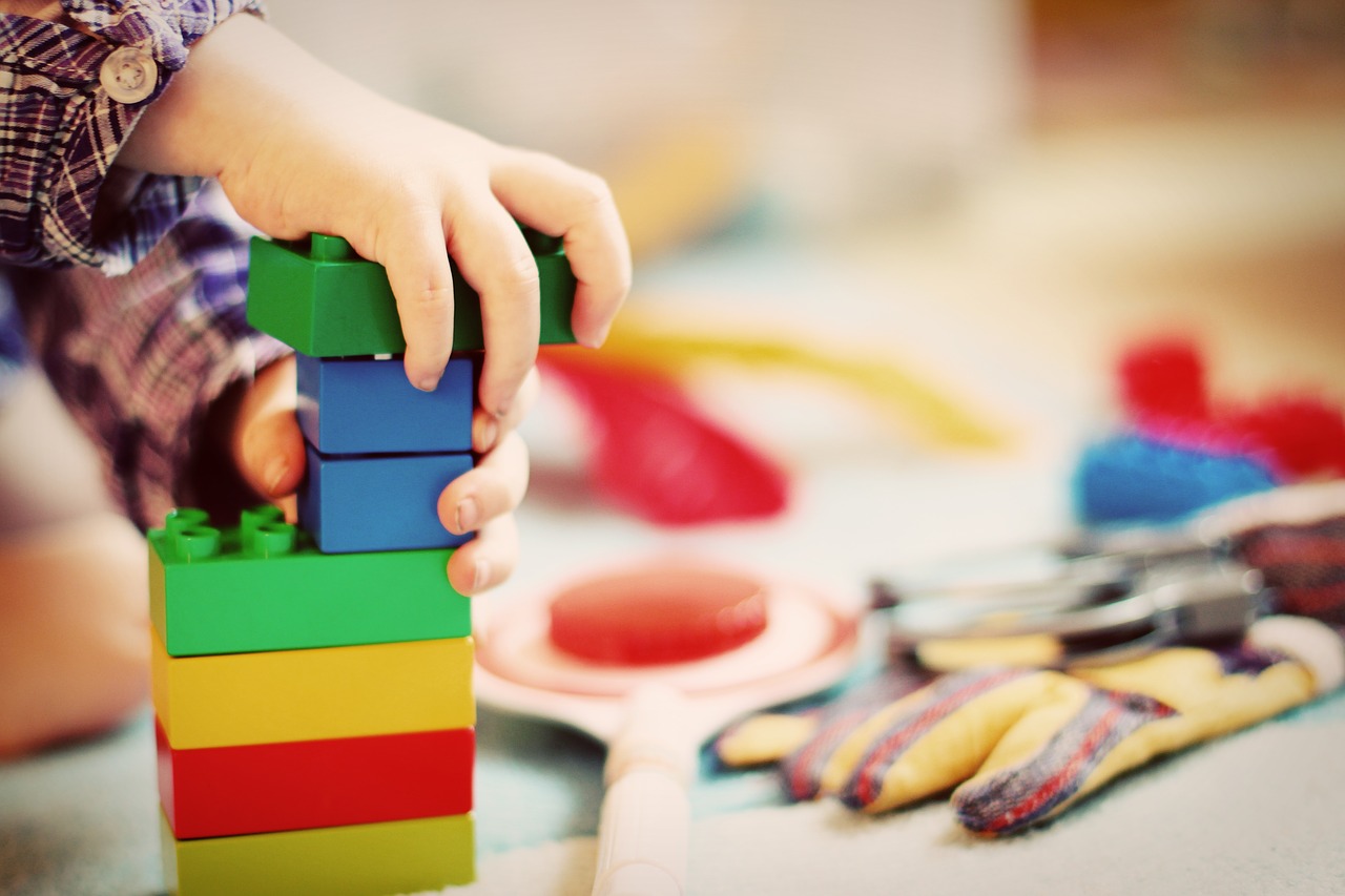 hand of a toddler playing colorful blocks