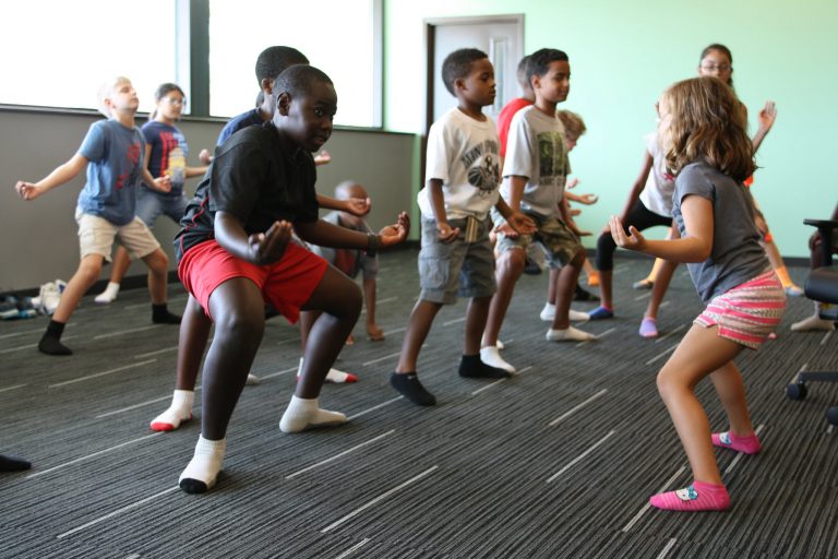 Group of kids doing a yoga pose.