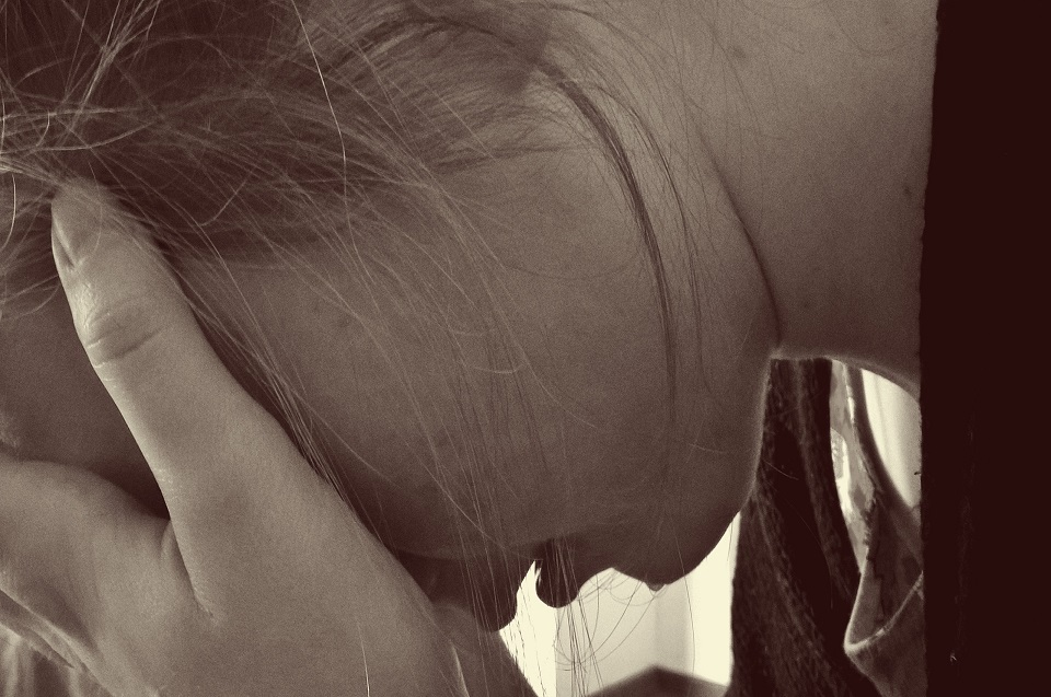 Teenage girl with her head in her hands. Depression is one component of teenage problems