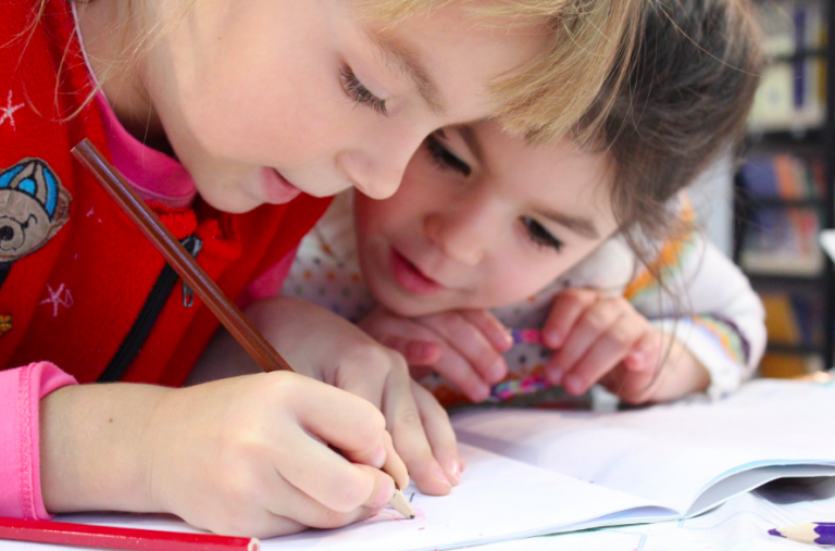 drawing ideas for kids: girls on desk looking at notebook
