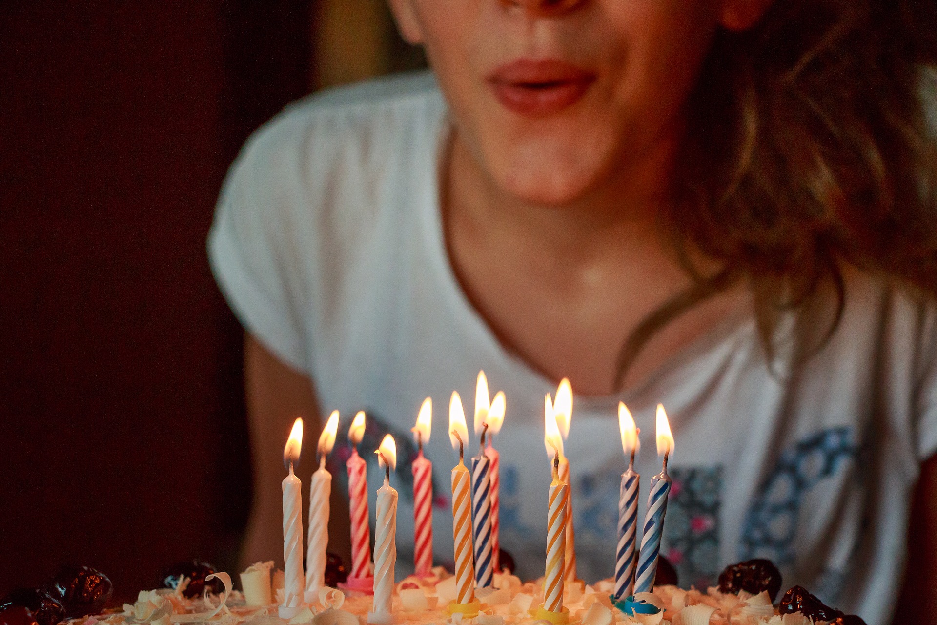 woman blowing candles in a cake